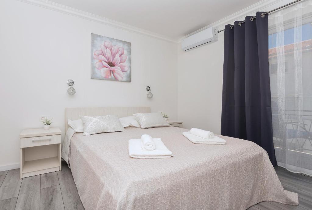 马卡尔斯卡Apartments PETRUSIC的一间卧室配有一张床,上面有两条毛巾