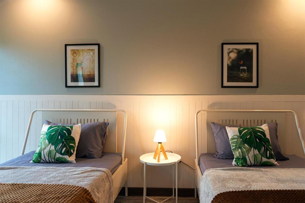 曼谷艺瑞奇公寓的一间卧室配有两张床和一张带台灯的桌子