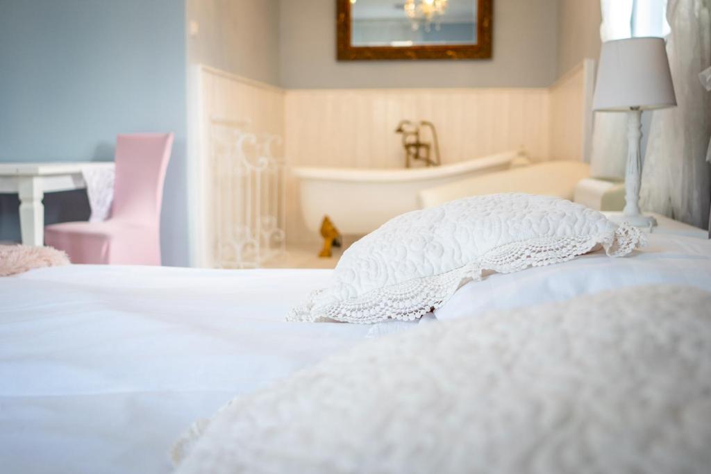 久洛久洛畔兹奥旅馆的卧室配有白色的床和浴缸