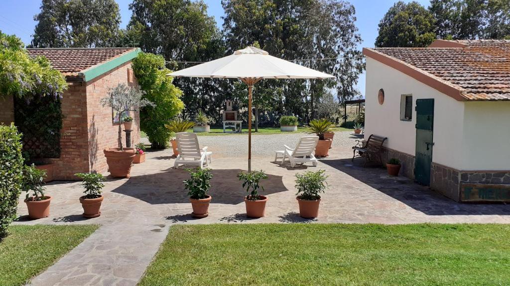 普林希匹纳马尔Agriturismo Prato Verde的庭院里设有带椅子和遮阳伞的庭院。