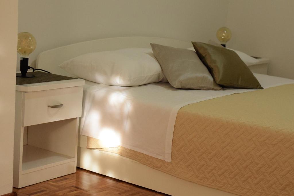 沃迪切Studio apartman MARINA的白色的睡台和白色的四柱床