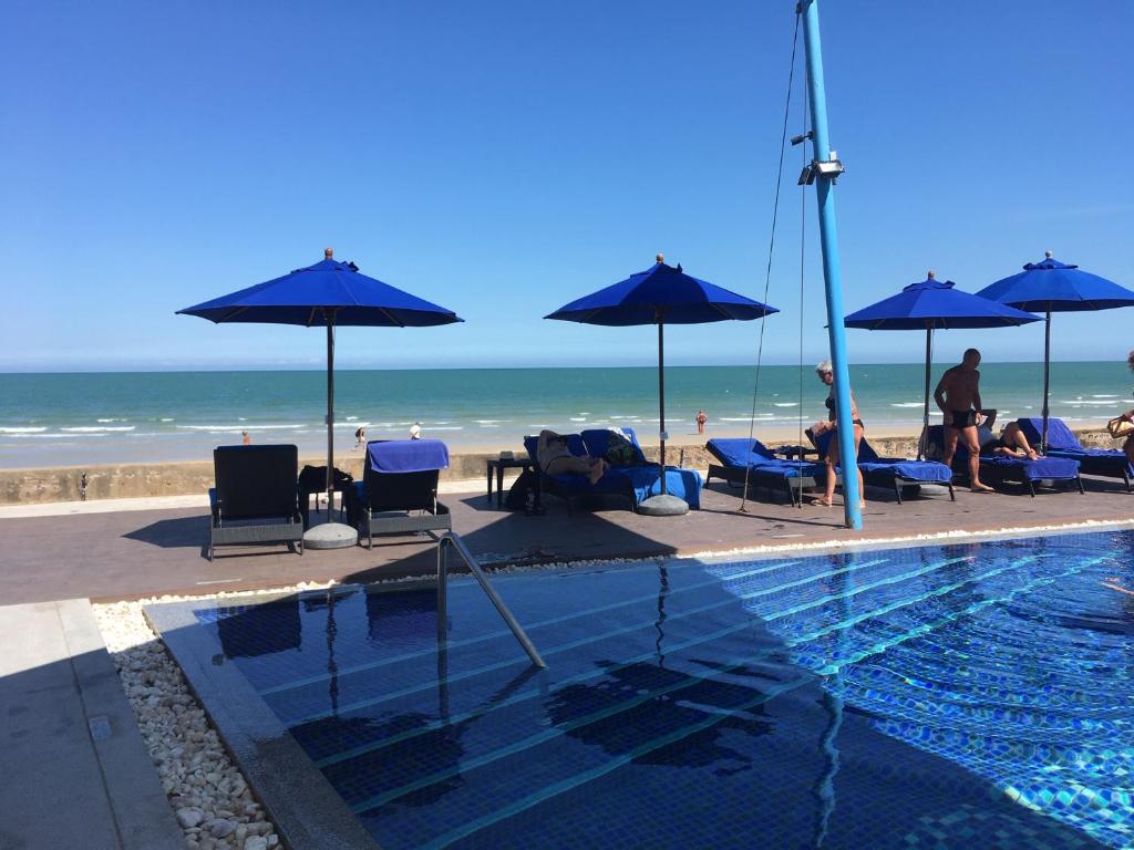 考陶Amari Residence的海滩上带遮阳伞和人员的游泳池
