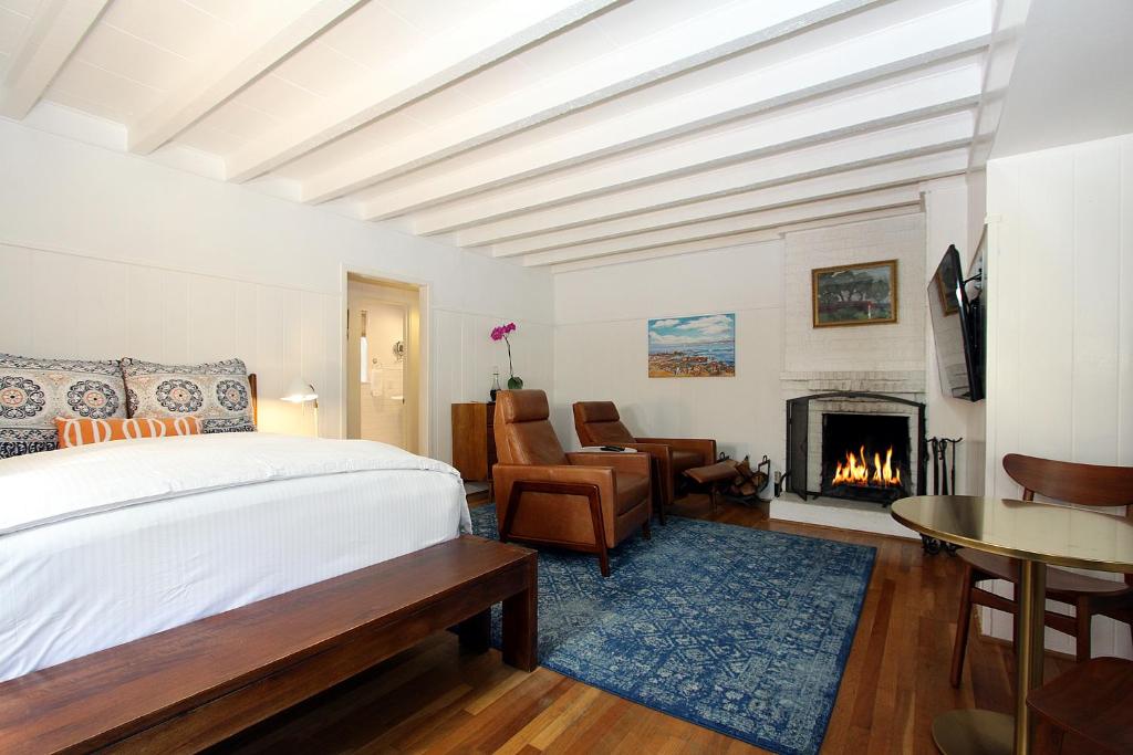 卡梅尔凡噶邦德之家精品酒店的一间卧室配有一张床和一个壁炉