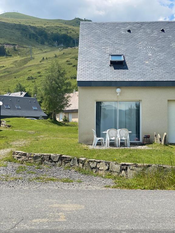 瓦尔卢龙Chalet de montagne au pied des pistes station Val Louron的房屋设有两把白色椅子和窗户