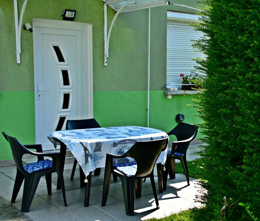 瑙吉考尼饶Tiszafa Vendégház Nagykanizsa的一个带门的庭院里的桌椅