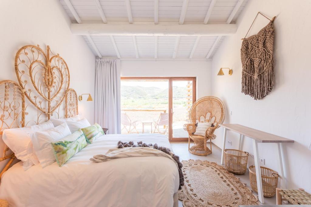 卡拉帕泰拉Hortas do Rio - Casa de Campo的一间卧室设有一张大床和一个窗户。
