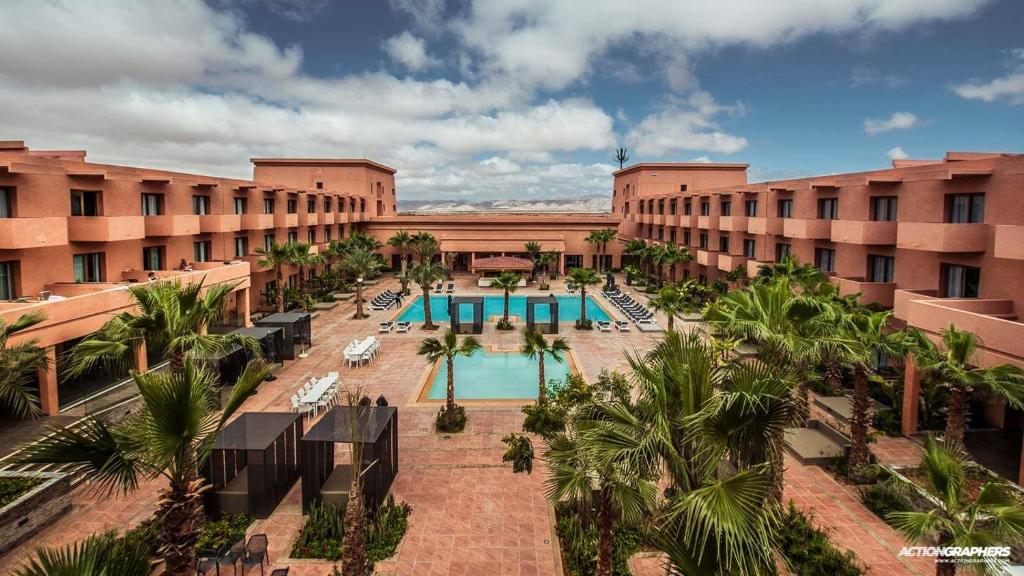 盖勒敏Oasis Palm Hotel的享有酒店顶部的景色,设有游泳池和棕榈树