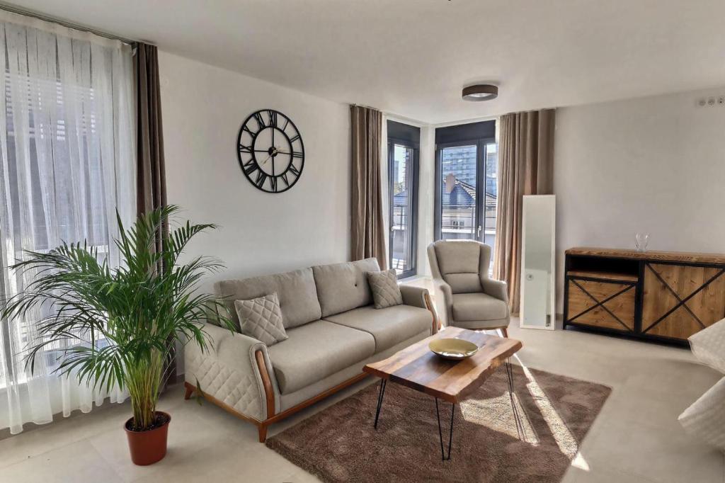 圣路易KRésidence - Appartements Saint-Louis的客厅配有沙发和桌子