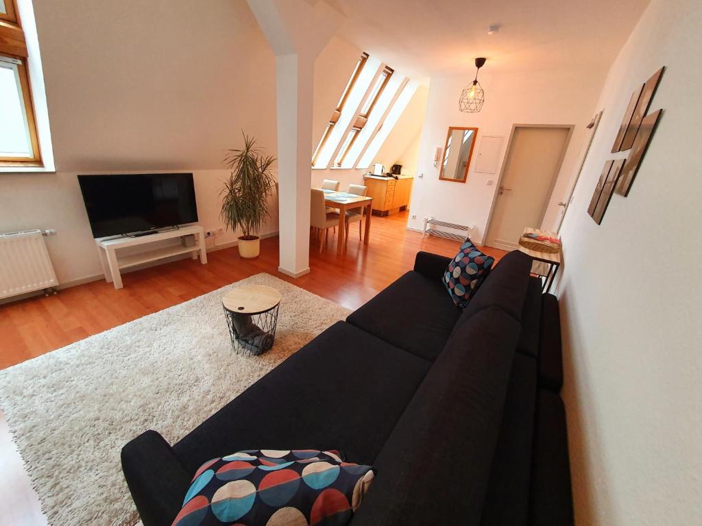 比勒费尔德Zentrales Dachgeschoss-Apartment Bielefeld的客厅配有黑色沙发和电视