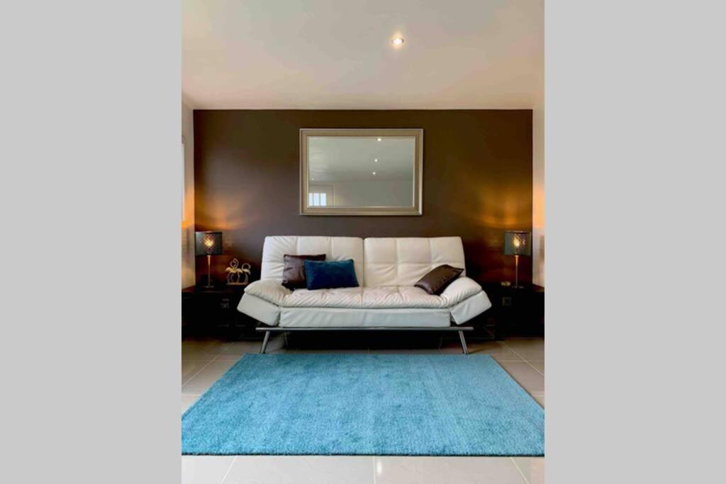 马尼库尔勒翁格尔Appartement 3km Disneyland Paris 4 à 6 personnes的客厅配有白色沙发和蓝色地毯。