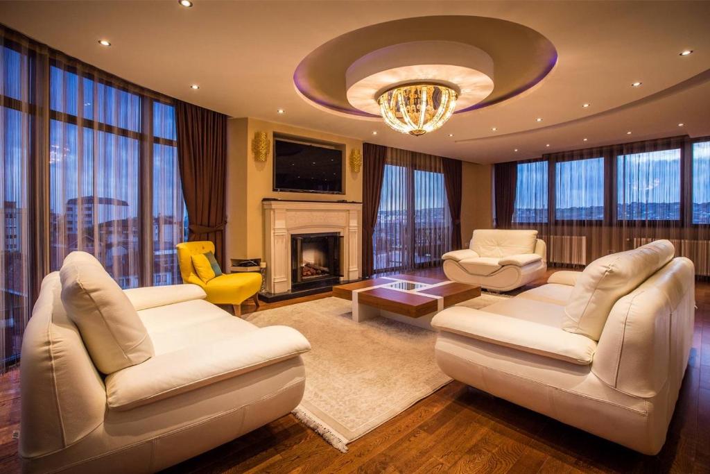普里什蒂纳Bentley Apartments的大型客厅配有白色家具和吊灯。
