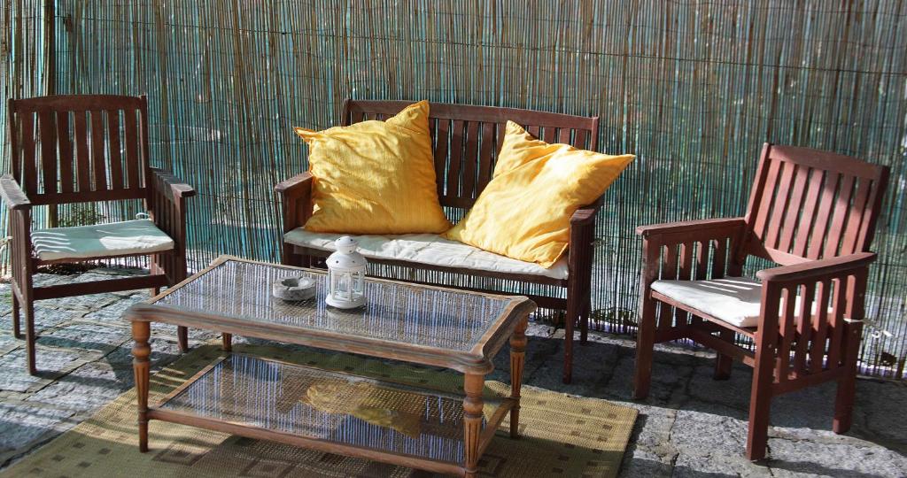 费拉约港Agriturismo dei girasoli的一张沙发,沙发上摆放着黄色枕头,坐在两把椅子之间