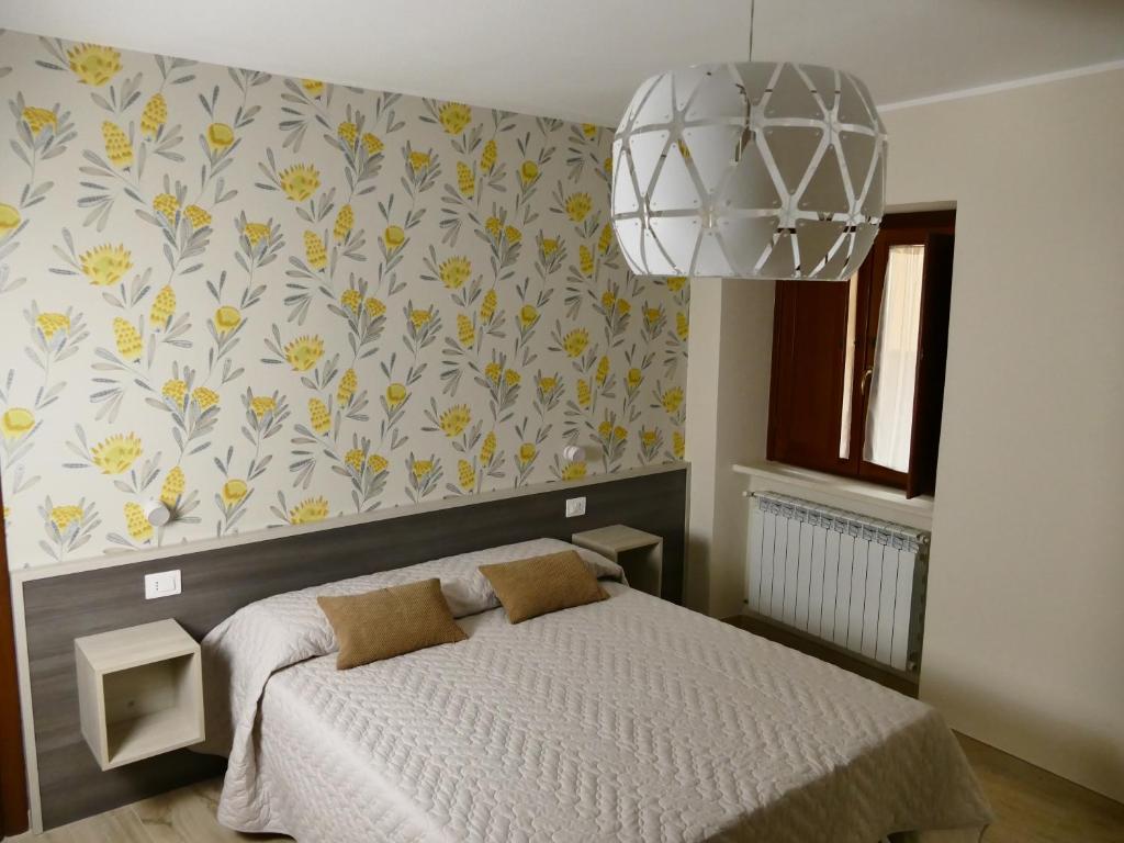 拉奎拉IL NIDO L'Aquila的一间卧室设有一张床和华丽的墙壁