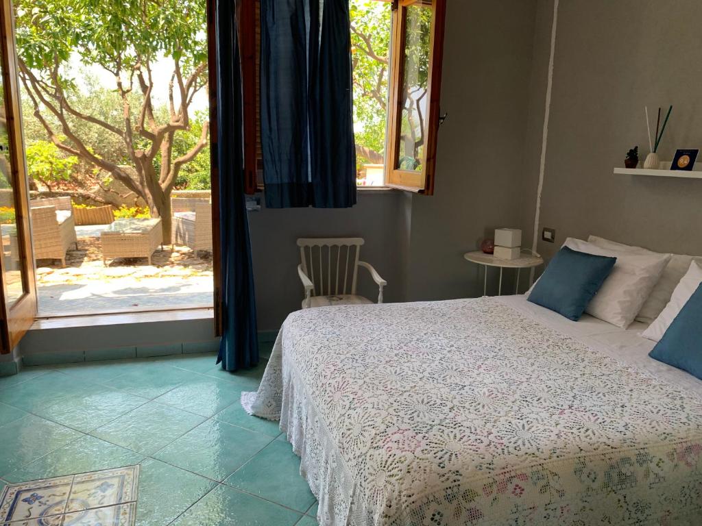 马拉泰亚B&B Blanda的卧室配有一张床,享有庭院的景色