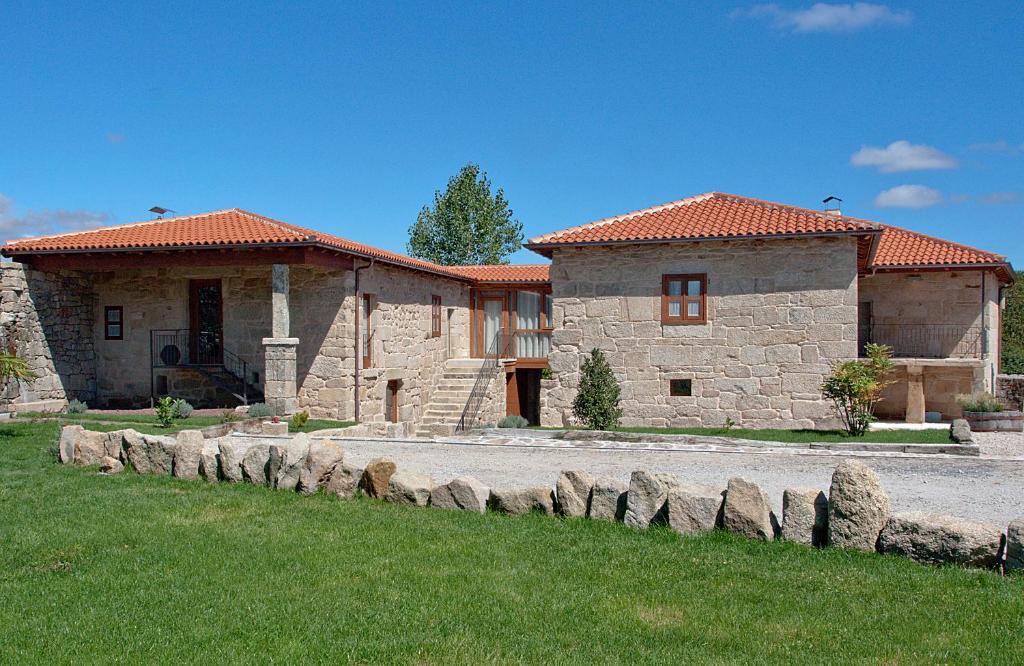 BoimortoCasa Rural Rectoral Santa Baia的一座大型石头房子,前面有一个草地庭院