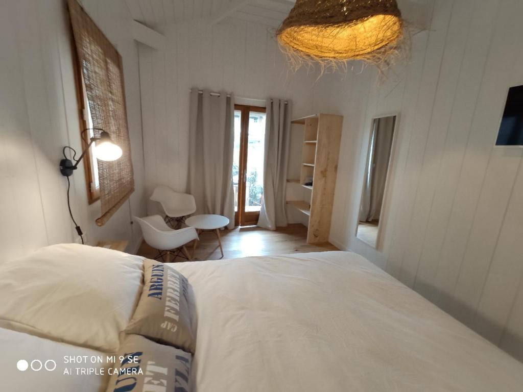 BélisaireCentre Cap-ferret, les chambres du phare, océan的卧室配有白色的床和窗户。