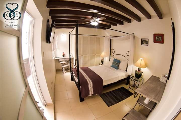 克雷塔罗Hotel Tres Sofias的一间卧室配有一张床、一张桌子和一个窗户。