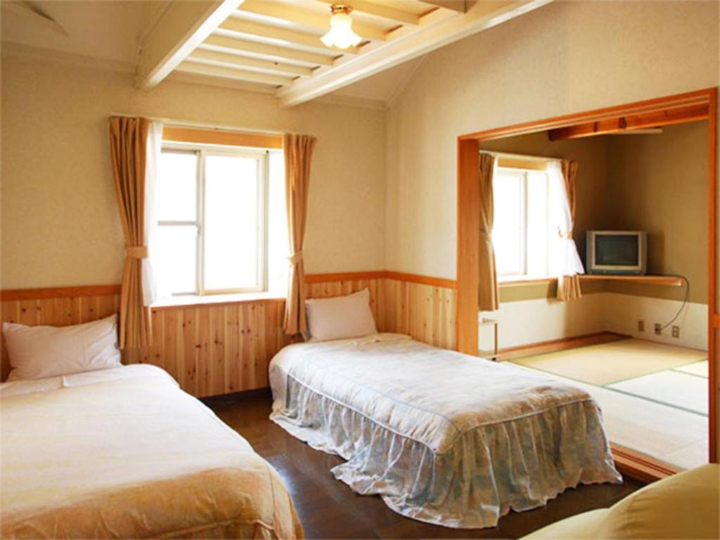 Kusakabeolive no sato vingh four eyes shodoshima / Vacation STAY 79065的一间卧室设有两张床、镜子和两个窗户