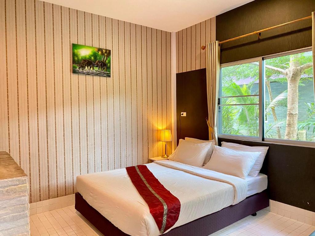 奈扬海滩运河度假村的一间卧室设有一张大床和窗户