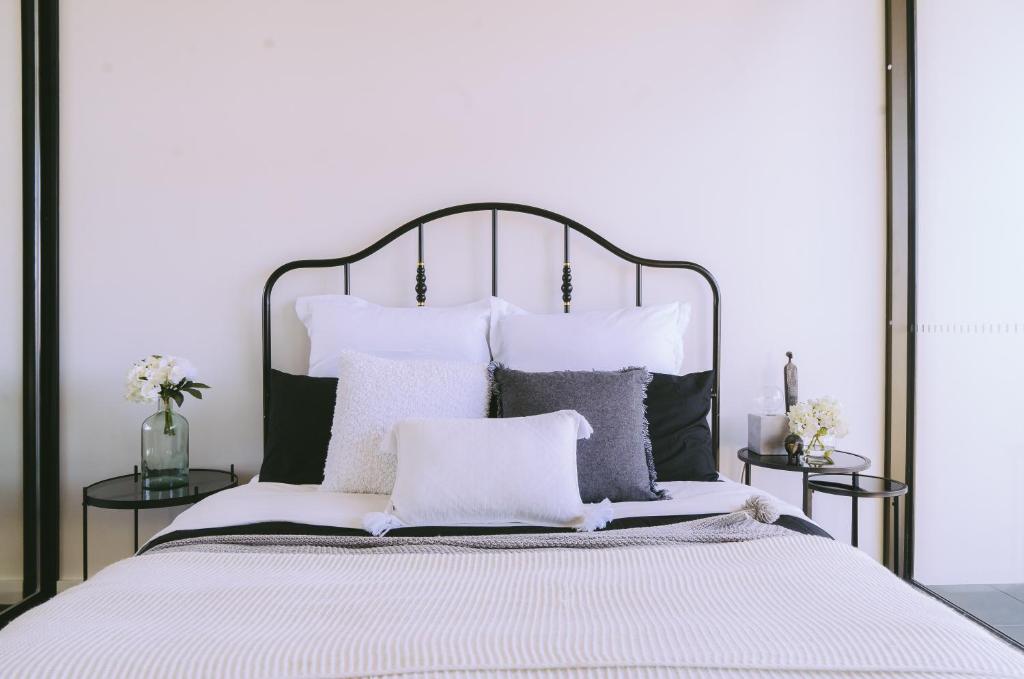 堪培拉Capitol Executive Apartment on London Circuit的卧室配有带枕头的大型白色床