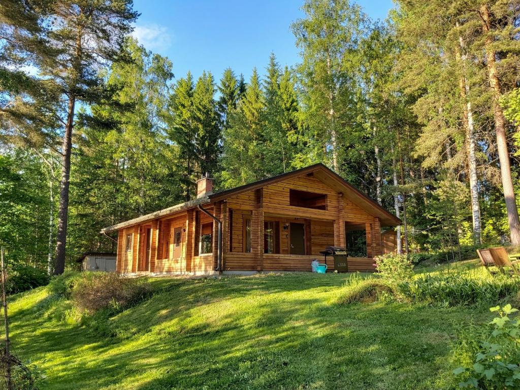 VihtavuoriKuhajärven Suviranta cottage的树林中的小木屋,带院子