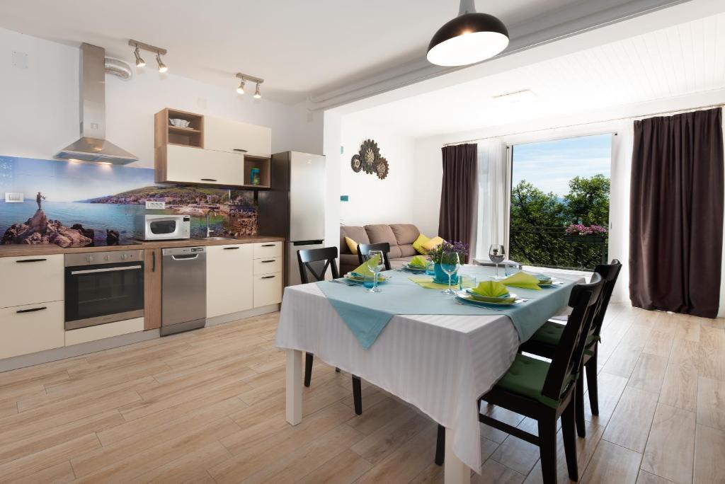 奥帕提亚Apartment Majda Opatija的厨房以及带桌椅的用餐室。