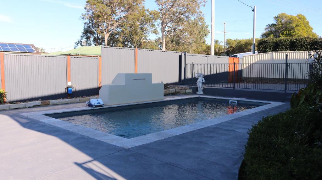 GorokanLa Nest Private Studio的后院的游泳池,带消防栓