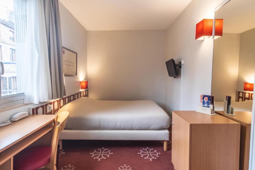图卢兹奥尔斯布兰科酒店的配有一张床和一张书桌的酒店客房