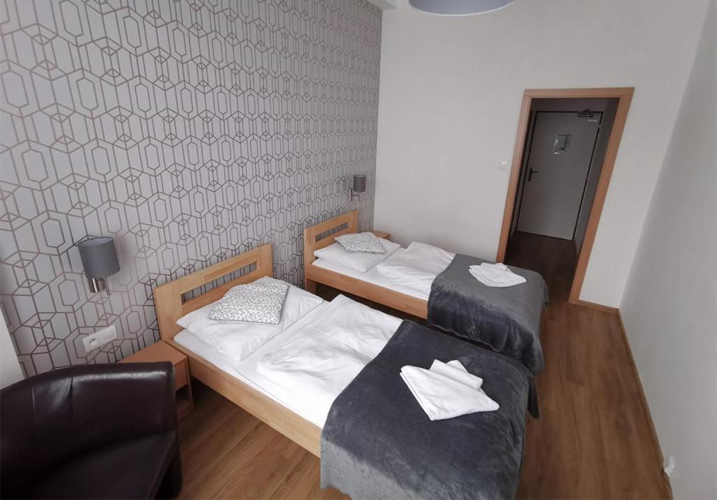 斯皮什新村普利维扎酒店的一间设有两张床和椅子的房间