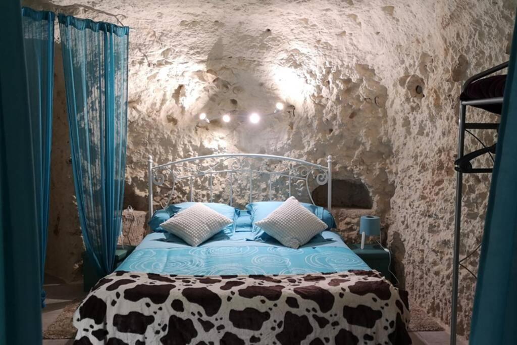 LunayCaves du coteau 1的卧室配有一张石墙床