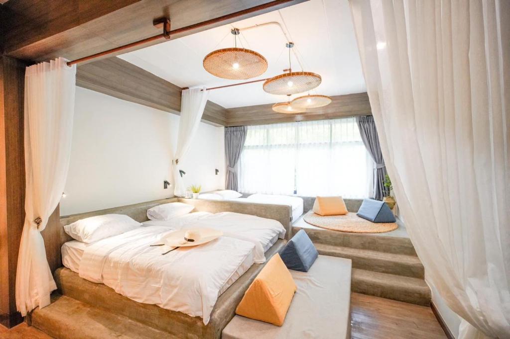 曼谷Krung Boutique Hotel的一间卧室设有两张床和窗户。