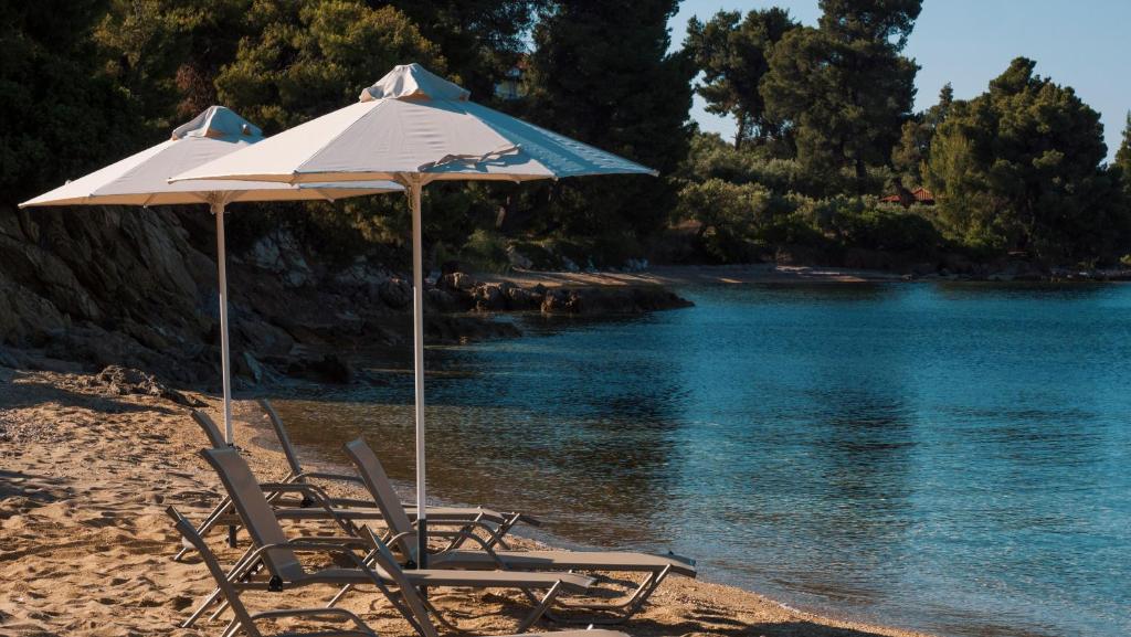 埃利亚Casa Bloo Adults Only的海滩上的两把椅子和一把遮阳伞