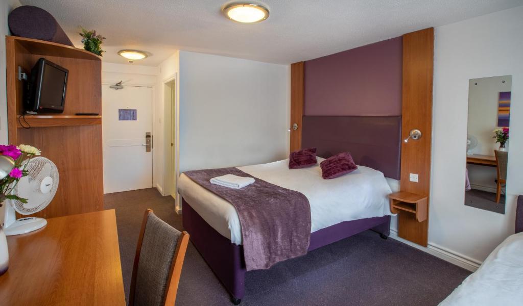 索利赫尔Redwings Lodge Solihull的酒店客房配有一张床铺和一张桌子。