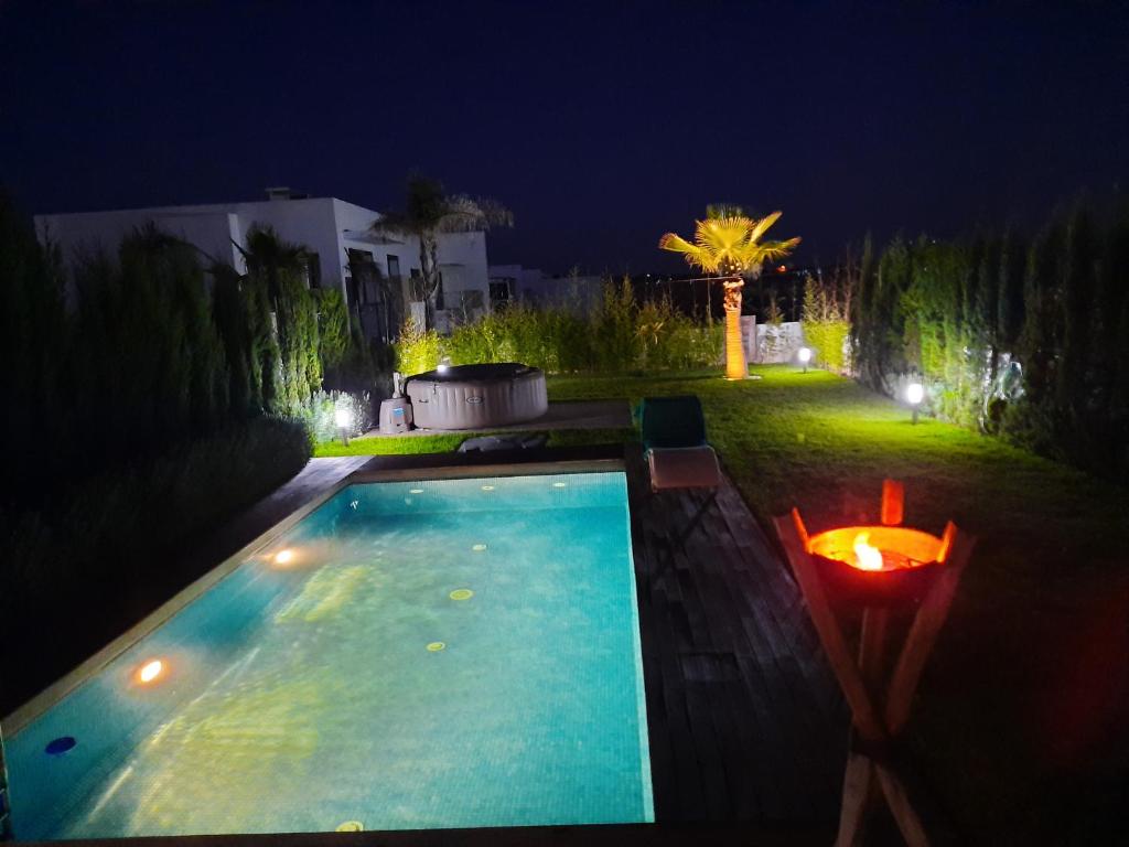 拉巴特SUPERBE VILLA AVEC PISCINE PLAGES DES NATIONS的夜间在院子里的游泳池