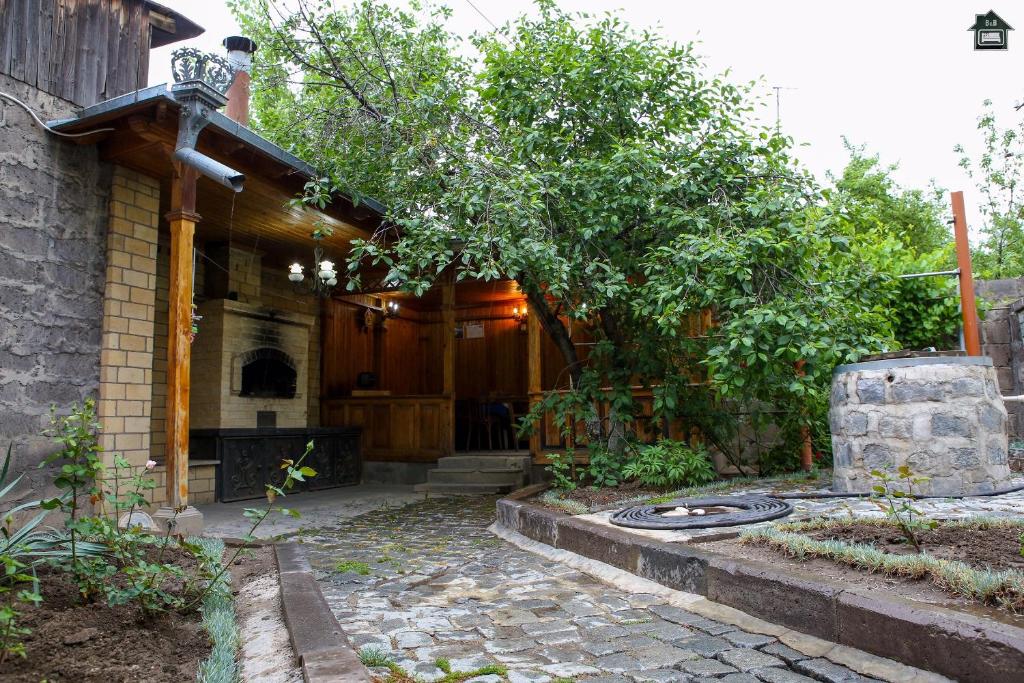 久姆里Guest House in Gyumri的一座带树和房子的庭院