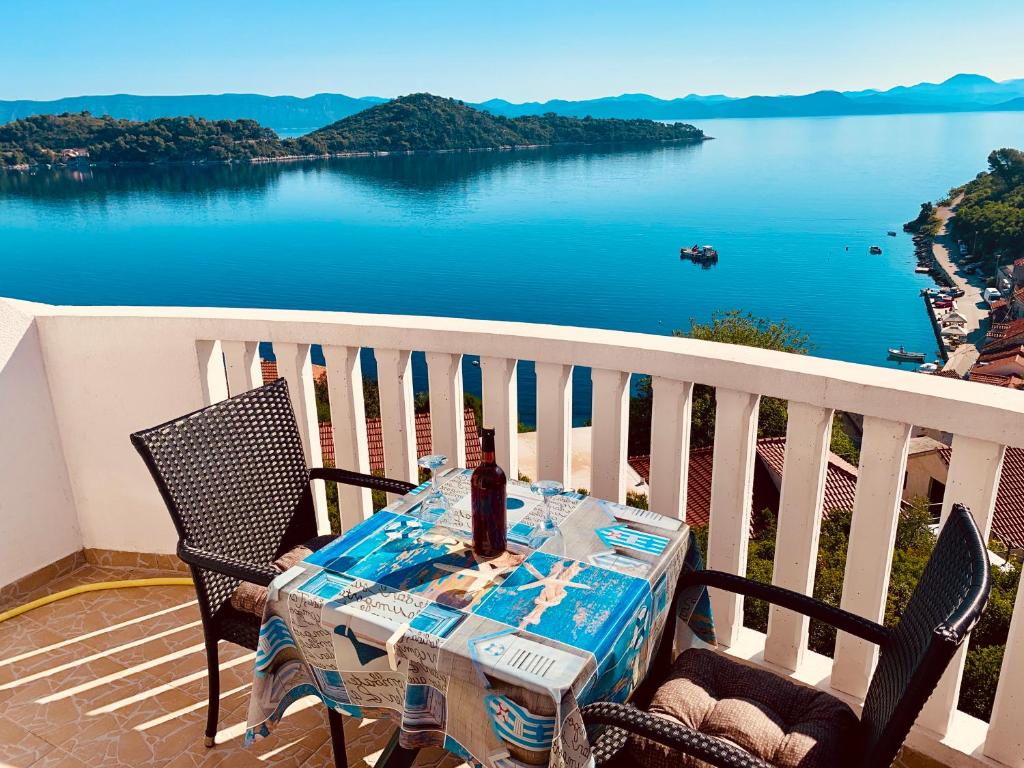 索布拉Guest House Ruža的阳台配有桌椅,享有水景