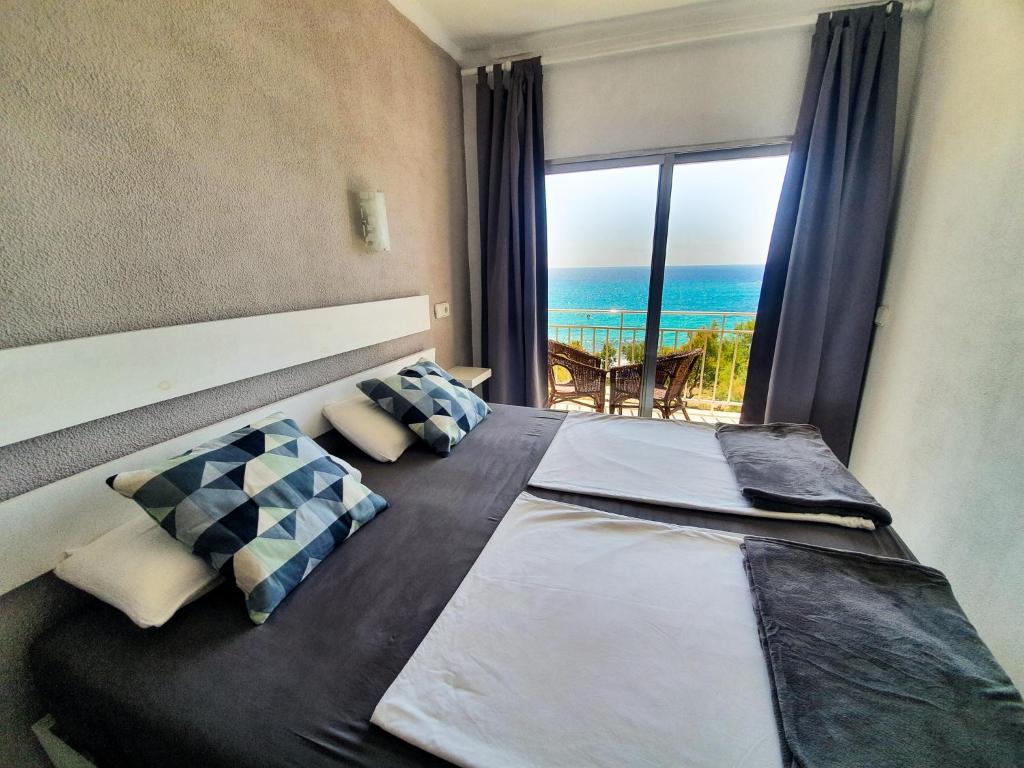 萨科马Amena Mar Hotel的一间卧室设有一张床,享有海景