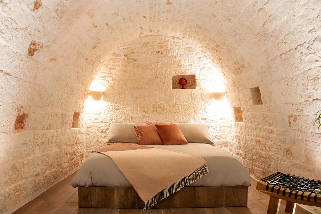 阿尔贝罗贝洛Monte Adamello - dimora nei trulli的卧室配有一张石墙床