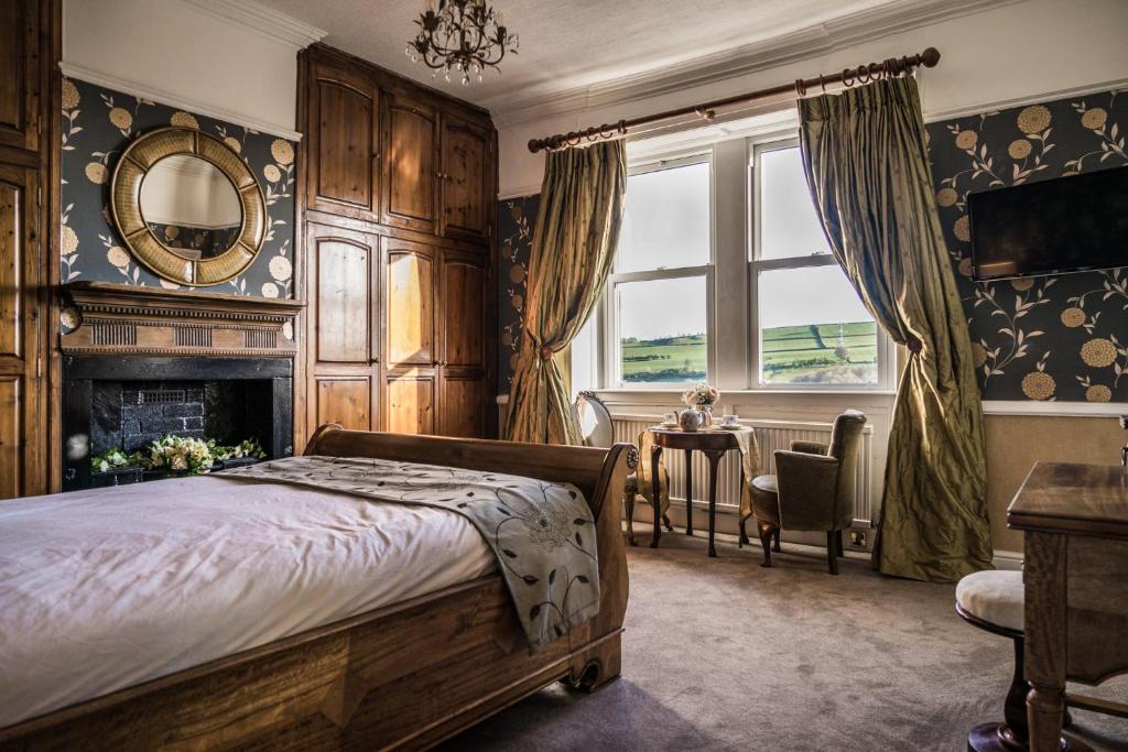 哈利法克斯Shibden Hall View的卧室配有床、壁炉和窗户。
