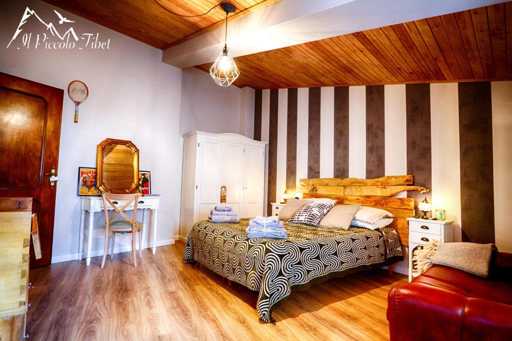 拉奎拉Il Piccolo Tibet - Gran Sasso的一间卧室配有一张床和条纹墙