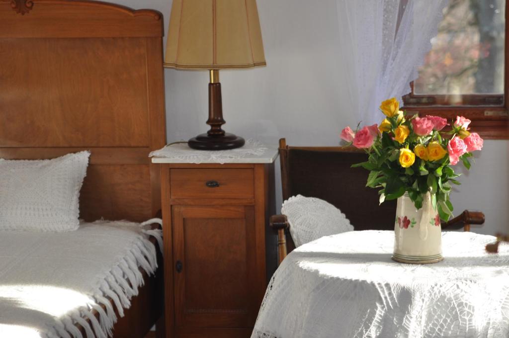 斯克拉斯卡波伦巴Villa Nostalgia的一间卧室,配有一张床,桌子上放着花瓶