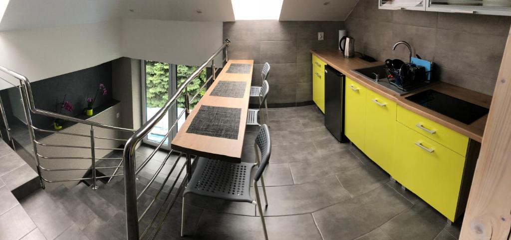 Wola KalinowskaNoclegi u Alicji的厨房配有黄色橱柜和桌椅
