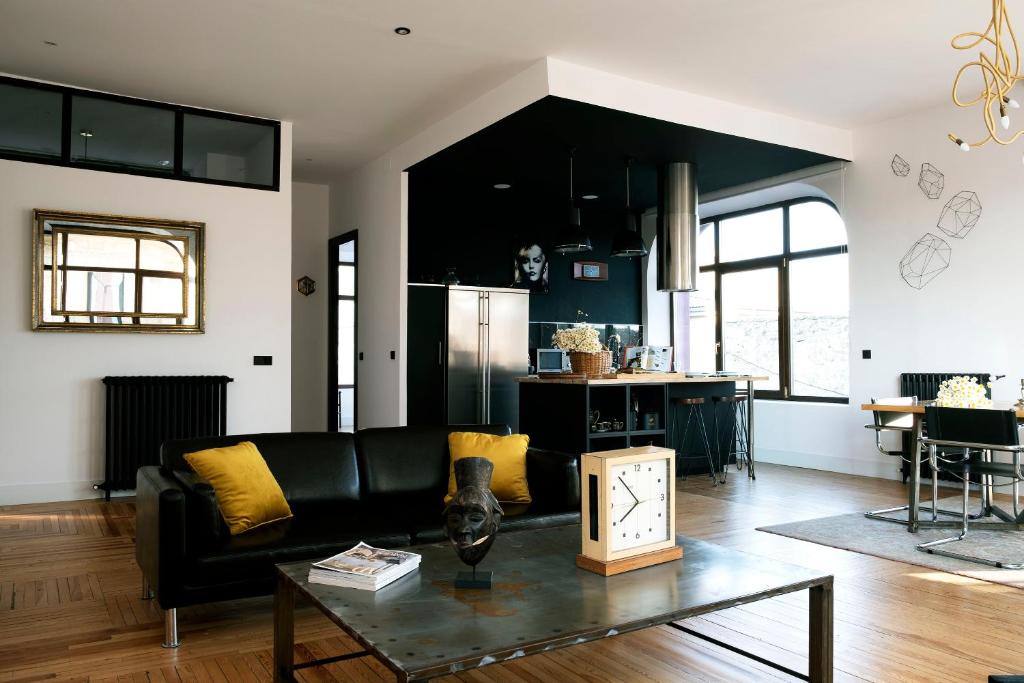 科瓦莱达Gran loft en los pinares de Covaleda, Soria的客厅配有黑色沙发和桌子