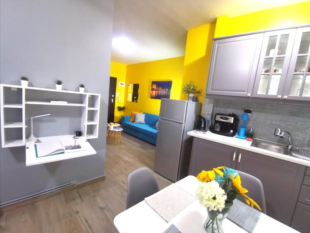 塞萨洛尼基N&N's Luxurious Suite #WhiteTower的一间带桌子的厨房和一间带黄色墙壁的厨房