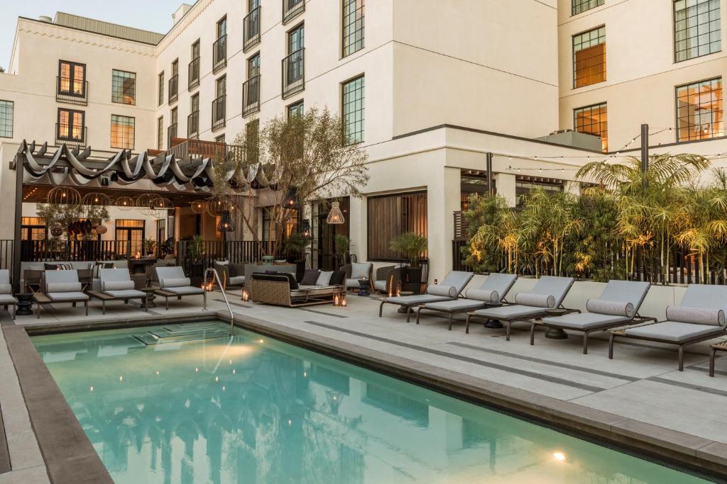 洛杉矶Kimpton La Peer Hotel West Hollywood, an IHG Hotel的酒店游泳池设有躺椅,酒店大楼