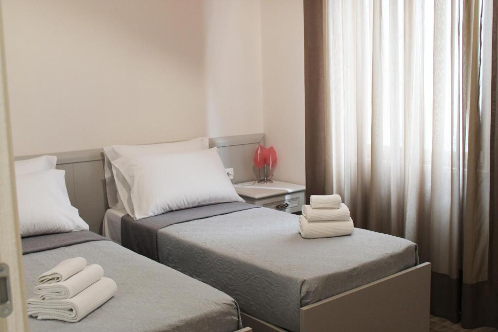波蒂奇L'Acchiappasogni Vesuviano Guest House的小客房内的两张床和毛巾