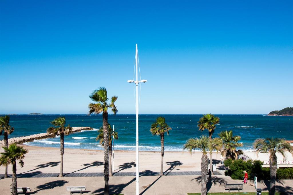 锡富尔勒普拉日贝尔阿祖尔酒店的棕榈树和海洋海滩上的十字路口