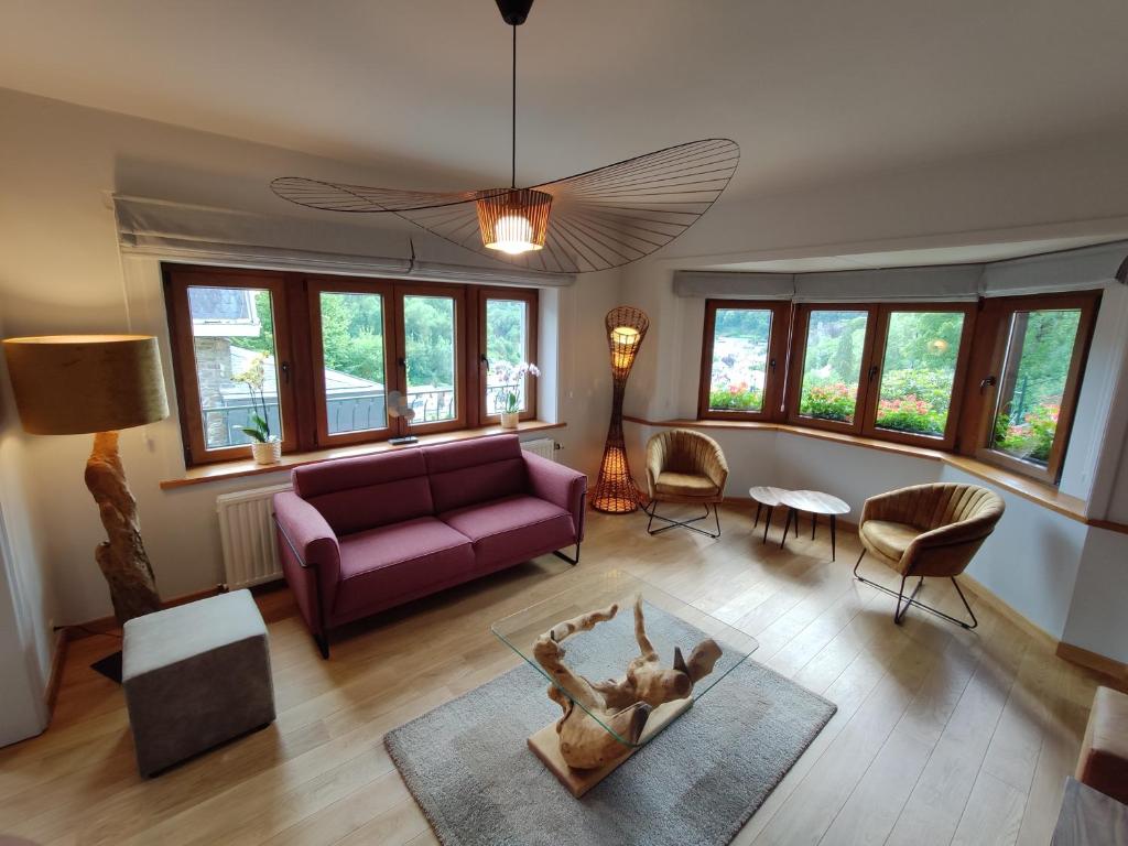 拉罗什-阿登Villa Le Genêt Fleuri的客厅配有紫色沙发和椅子