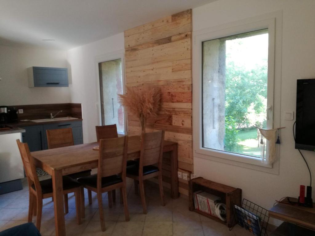 ÉchevisL'Echevine en vercors的一间带木桌和窗户的用餐室