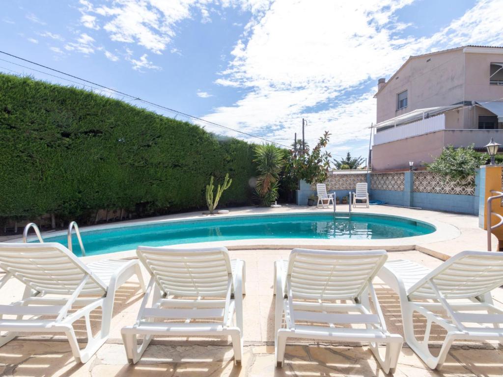 托里代巴拉Holiday Home Lleida by Interhome的一组椅子和一个游泳池